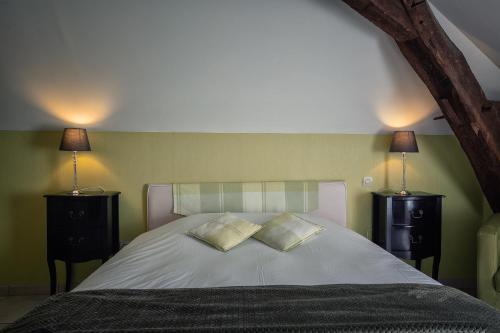 a bedroom with a bed with two lamps on it at Hôtel & Spa Chai De La Paleine in Le Puy-Notre-Dame