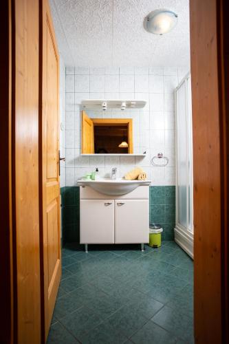 a kitchen with a white sink and a mirror at Korošec Apartments and Wellness Centre in Mozirje