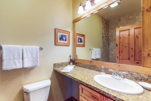 ein Badezimmer mit einem Waschbecken, einem WC und einem Spiegel in der Unterkunft Boulders Hideout in Truckee