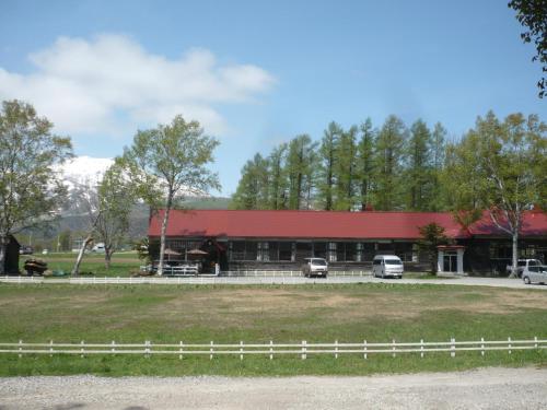 a red barn with cars parked in front of it at Boken Kazoku in Kutchan