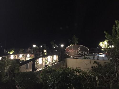 a sign for a hotel at night with lights at Alta Residences in Daraga