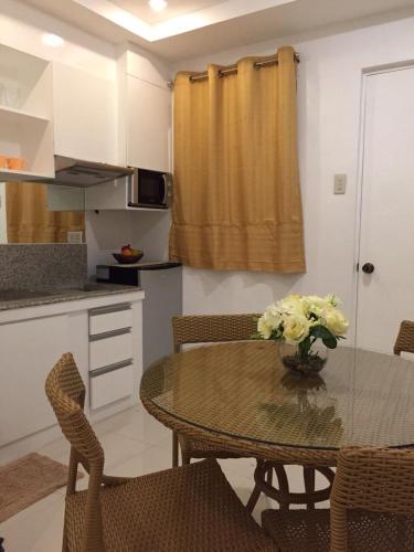 a kitchen with a table with a vase of flowers on it at Alta Residences in Daraga