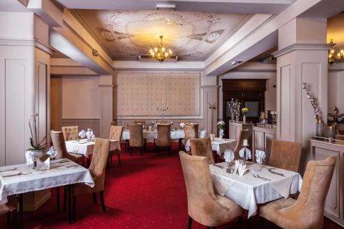 a dining room with tables and chairs and a chandelier at Hotel Cristal Park in Dąbrowa Tarnowska