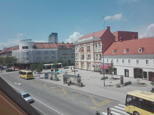 a city street with cars and a yellow bus at Studio apartman Karolina in Karlovac