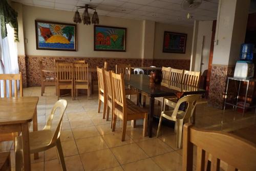 uma sala de jantar com mesas e cadeiras num restaurante em Lylie Hotel em Cebu