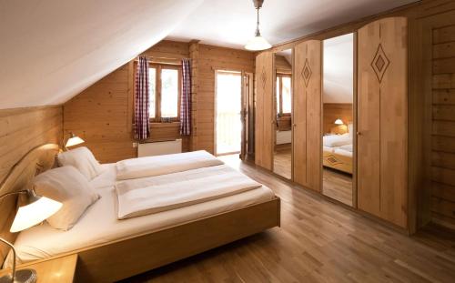 a bedroom with a large bed and wooden walls at MarktlAlm Turracher Höhe in Turracher Hohe