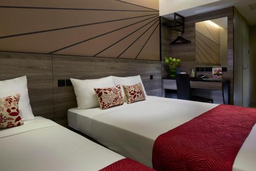 a hotel room with two beds and a desk at Hotel 81 Orchid in Singapore