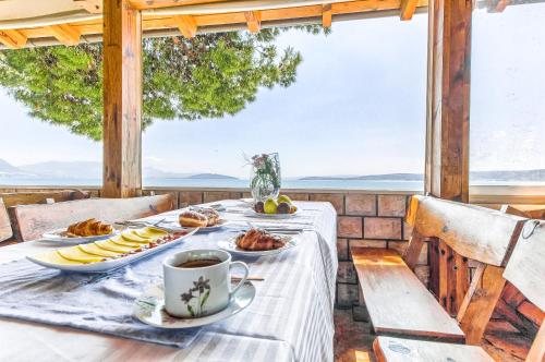 a table with plates of food and a cup of coffee at Apartments & Bungalows Ivanović in Kaštela