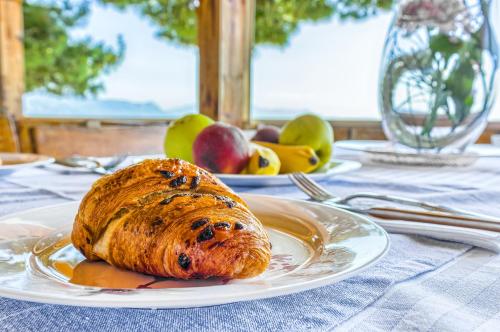 a loaf of bread on a white plate on a table at Apartments & Bungalows Ivanović in Kaštela