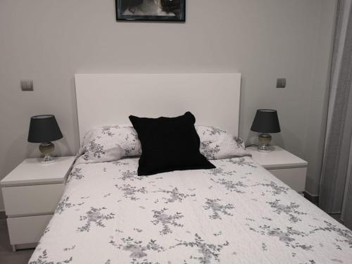 Un dormitorio con una cama con una almohada negra. en Nicoletta en Madrid