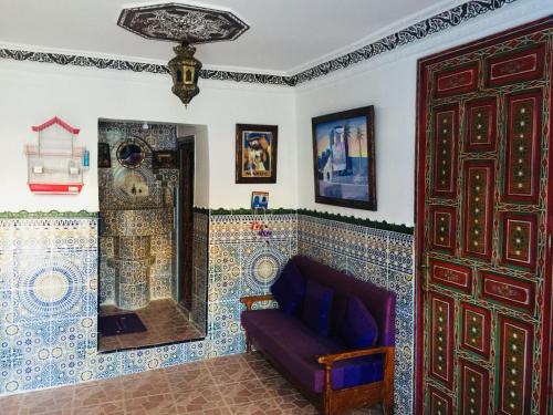Hotel Chefchaouen في شفشاون: غرفة معيشة مع أريكة وجدار بلاط