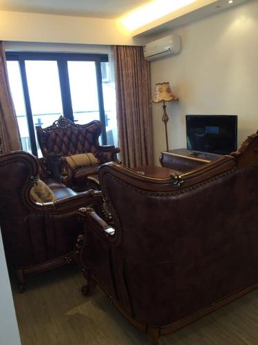 a living room with two chairs and a couch at Coast-Inn Hailing Island in Yangjiang
