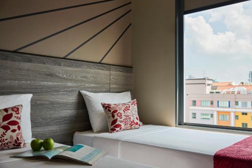 a room with a bed and a window at Hotel 81 Orchid - SG Clean in Singapore