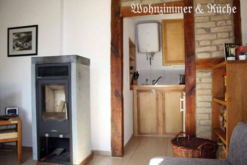 a living room with a fireplace and a kitchen at Ferienhaus Mien Hüsing in Stralsund