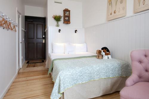 a bedroom with a bed with two dogs sitting on it at Hotel Kung Carl, WorldHotels Crafted in Stockholm