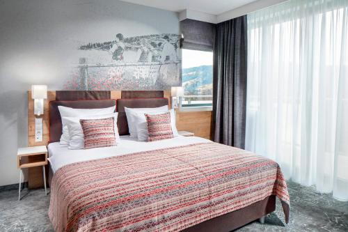 a bedroom with a large bed and a large window at Hotel Aquarion Family & Friends - Destigo Hotels in Zakopane
