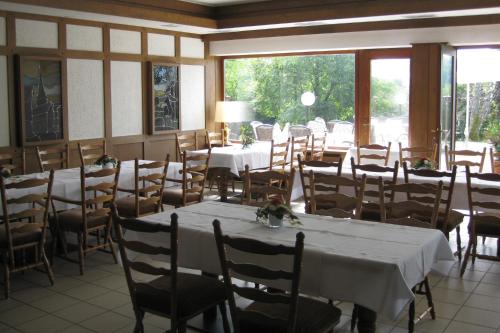 a dining room with tables and chairs and windows at Hotel Zur Suhle in Eschbach