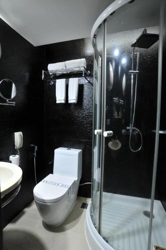a bathroom with a toilet and a glass shower at Platinum Residence in Dhaka