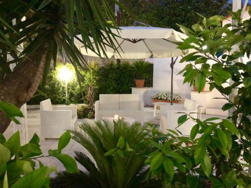 a group of white chairs and an umbrella at Villa Miriam in Gragnano