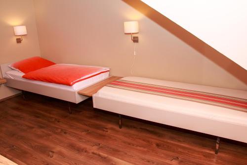 two beds in a small room with wood floors at Hotel Zur Suhle in Eschbach