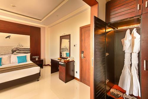 Habitación de hotel con cama y espejo en NorthGate Jaffna, en Jaffna