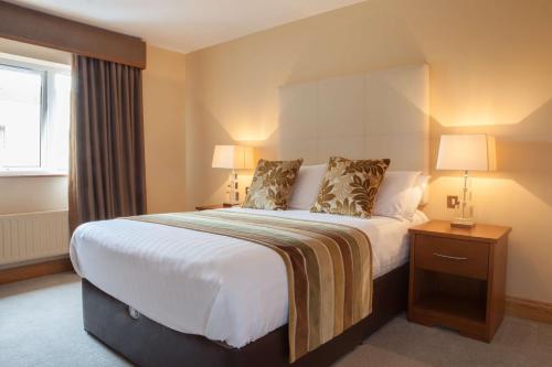 a hotel room with a large bed and a window at Four Seasons Hotel & Leisure Club in Monaghan