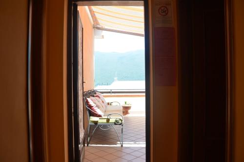 a door to a room with a chair and a balcony at Trentinara Cilento in Trentinara