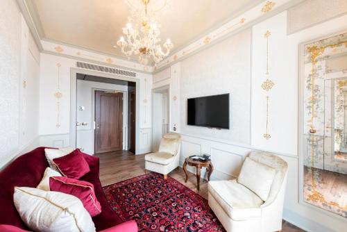 a living room with a couch and chairs and a tv at Monaco & Grand Canal in Venice