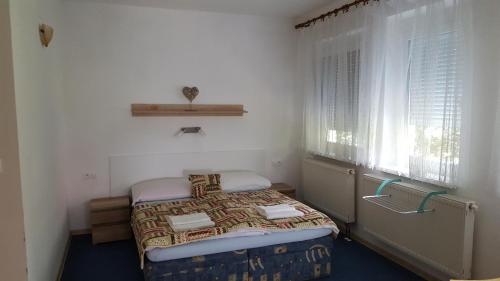 a small room with a bed and a window at Chata Triomint in Senec