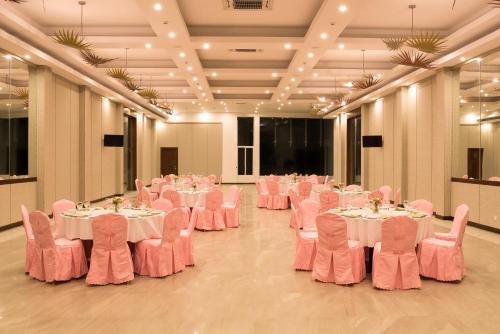 a room with tables and chairs with pink chairs at NorthGate Jaffna in Jaffna