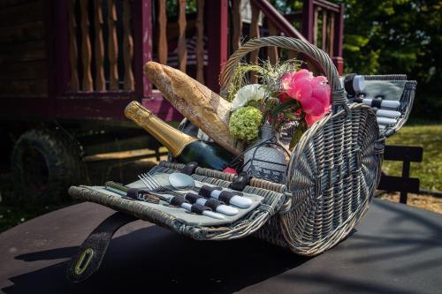 a wicker basket with medicines and flowers on a table at Hôtel & Spa Chai De La Paleine in Le Puy-Notre-Dame
