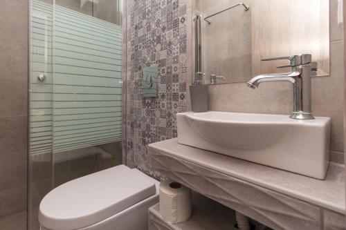 a bathroom with a sink and a toilet at Akti Alegra Apartment in Neos Marmaras