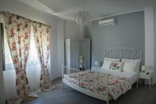 a bedroom with a bed with a floral bedspread at Villa Nicolas Plataria in Plataria