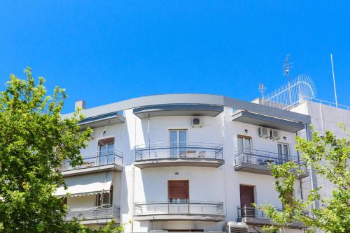a white building with balconies and a blue sky at Kalamata Art Rooms in Kalamata