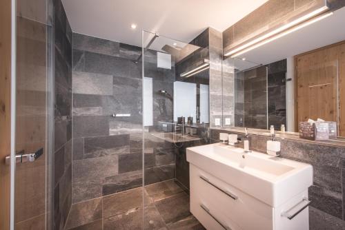 een badkamer met een wastafel en een glazen douche bij Bernstein in Grindelwald
