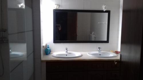 a bathroom with two sinks and a mirror at Casa das Flores in Albufeira