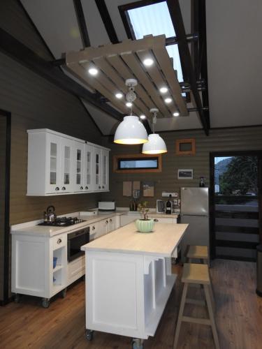 a kitchen with white cabinets and a white counter top at Timmerstuga in Malelane