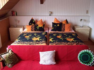 ベルンカステル・クースにあるAnneliese Schmitgenの赤いソファ付きの客室内のベッド2台