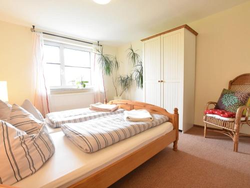 1 dormitorio con 2 camas, silla y ventana en Idyllic Apartment in Stellshagen on Baltic Sea Coast, en Stellshagen