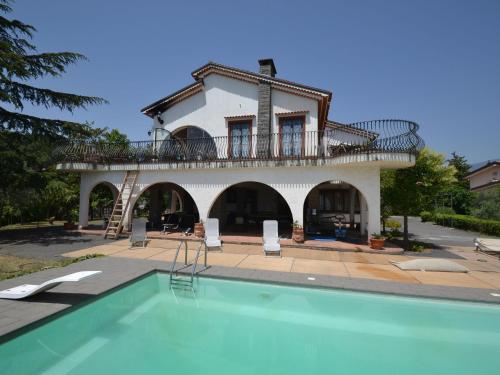 une villa avec une piscine en face d'une maison dans l'établissement Belvilla by OYO il Portico, à Trecastagni