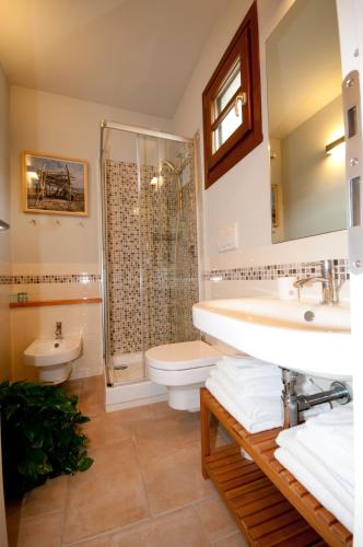 a bathroom with a sink and a toilet and a shower at Hotel La Posta di Torrenova in Orbetello