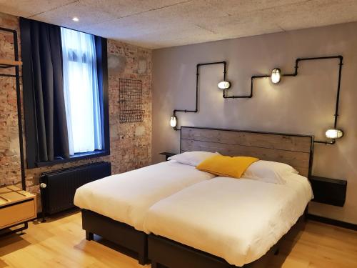 a bedroom with a large bed and a window at Upstairs Hotel in Ostend