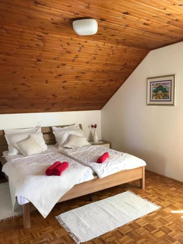 sypialnia z łóżkiem z czerwonymi kapciami w obiekcie Apartments Biskup w mieście Privlaka