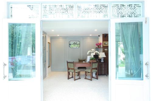 an open door into a dining room with a table at Villa Amphawa in Amphawa