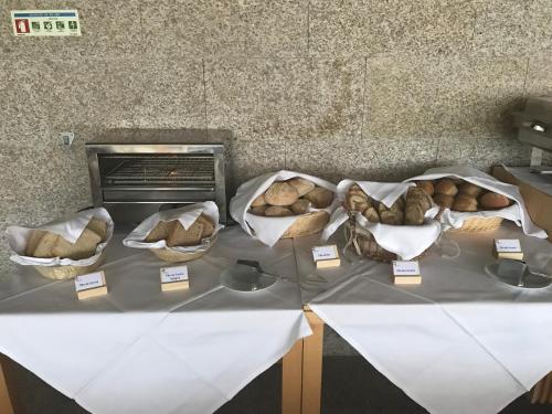 a table with three baskets of bread on it at Cró Hotel Rural in Rapoula do Côa