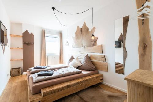 a bedroom with a bed with a wooden bench at Exklusive Design Erlebnisferienwohnung in Bad Wörishofen