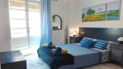 a bedroom with a large bed with blue pillows at Príncipe C in Granada