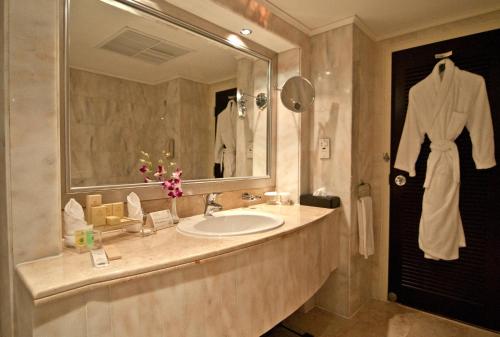 a bathroom with a sink and a large mirror at Danat Al Ain Resort in Al Ain