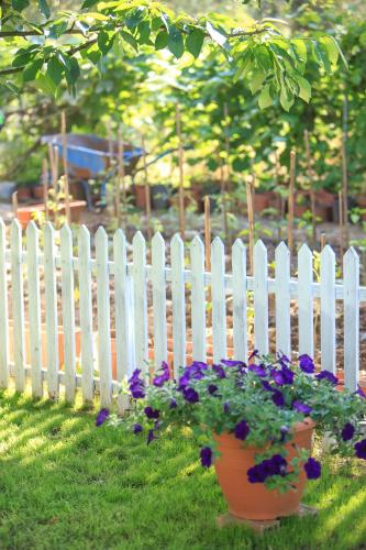a white picket fence with flowers in a yard at The Olive Garden in Limenas
