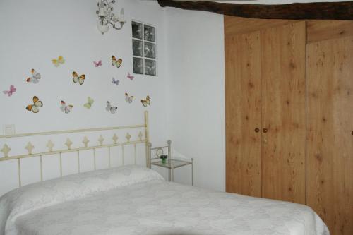 a bedroom with a bed with butterflies on the wall at Casa rural El Majuelo in Portera